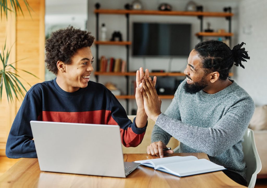 Older man and younger man high fiving
