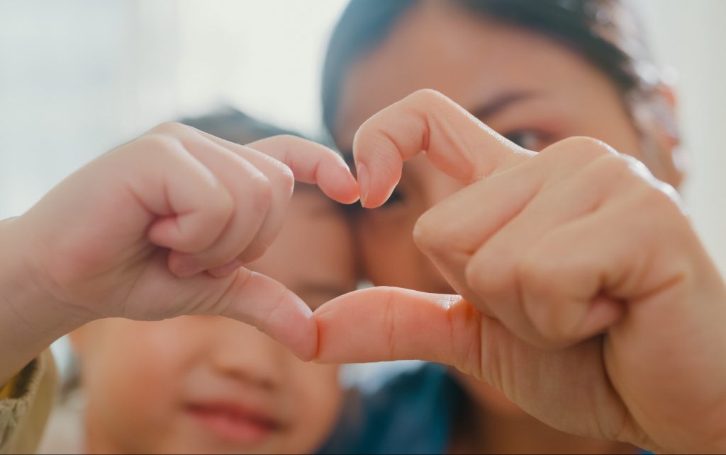 Mother and child making fingers heart shaped signs