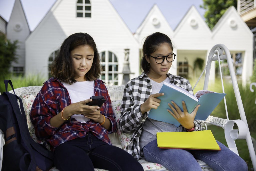 Teenagers sitting outside house