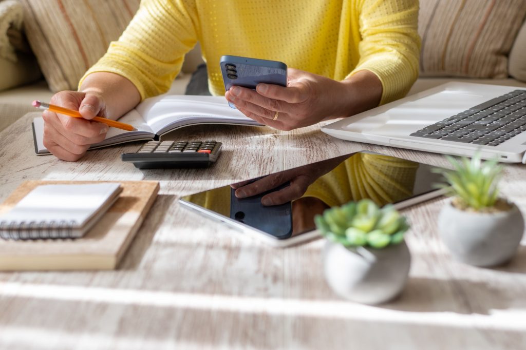 Person at a table with notebooks and electronics
